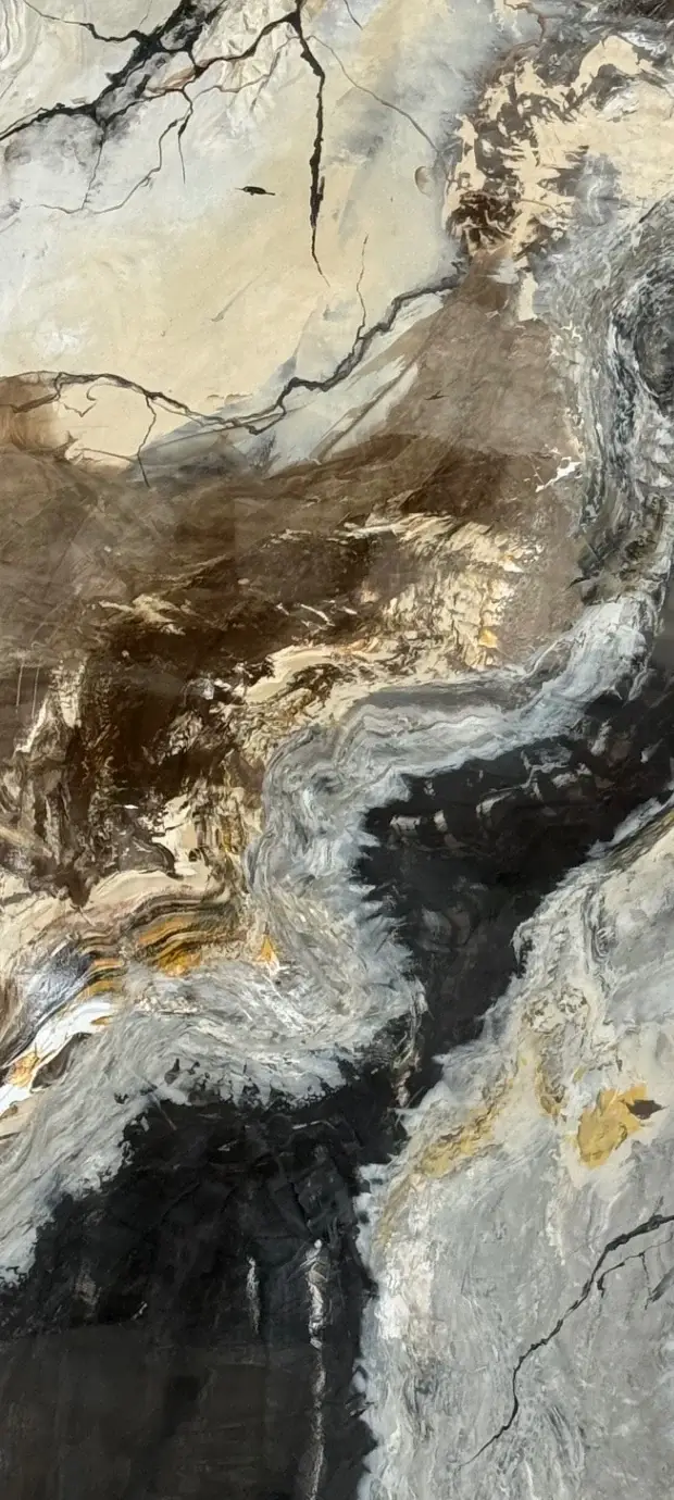 Close-up van een handgemaakt marmerpaneel in crème, zwart en okergoud met scherpe aderranden